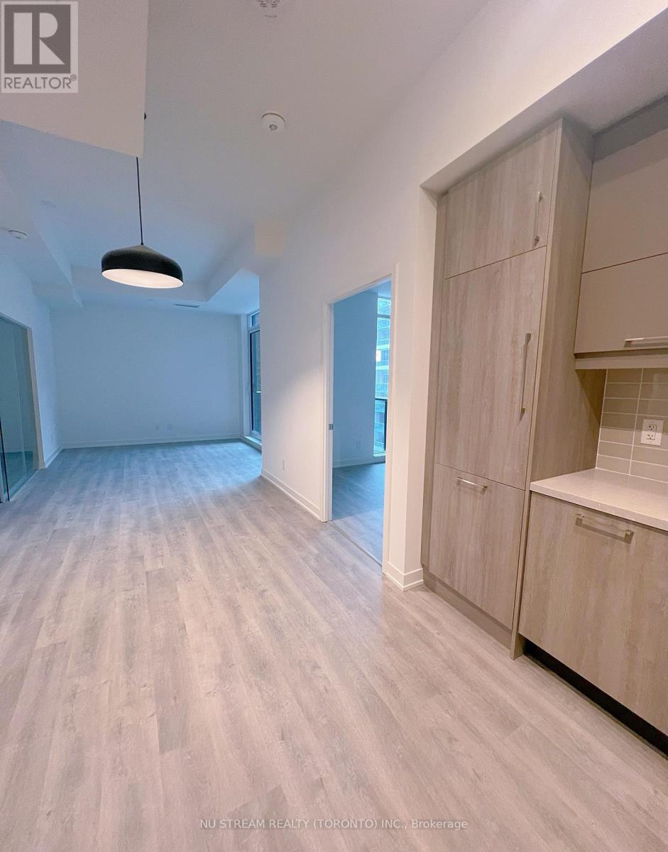 A spacious room with wooden flooring and a large open door.