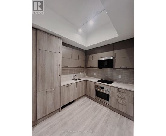 A modern kitchen with wooden cabinets and a stainless steel oven.