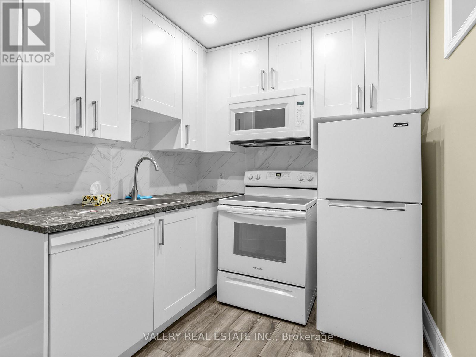 A kitchen with white appliances and cabinets.