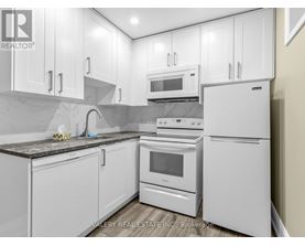 A kitchen with white appliances and cabinets.