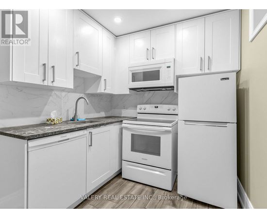 A kitchen with white appliances and cabinets.