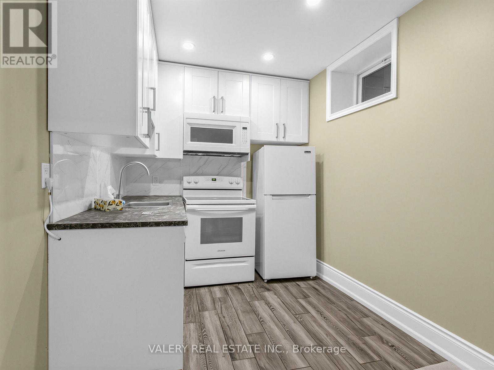 A kitchen with white appliances and a granite countertop.