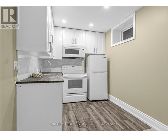 A kitchen with white appliances and a granite countertop.