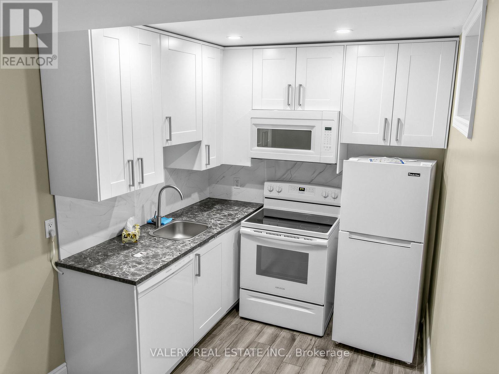 A kitchen with white appliances and cabinets.
