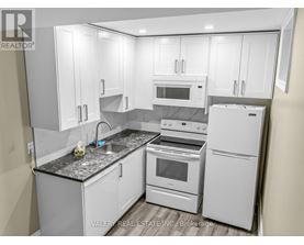 A kitchen with white appliances and cabinets.