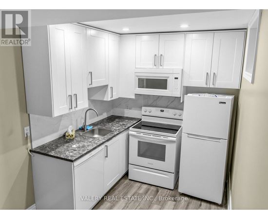 A kitchen with white appliances and cabinets.