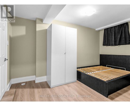 A bedroom with a bed, wardrobe and cupboard.