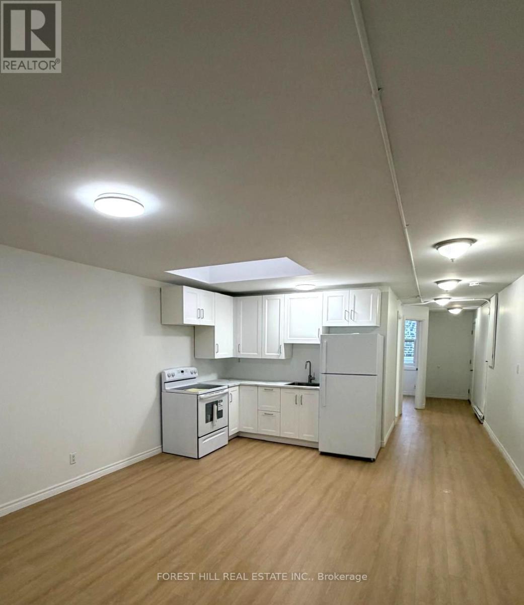 A kitchen with white appliances and wooden floors.