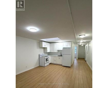 A kitchen with white appliances and wooden floors.