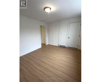 A room with wooden flooring and white walls.