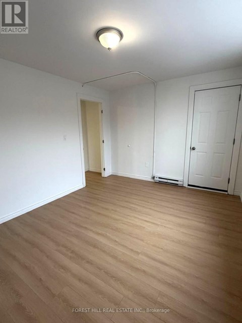 A room with wooden flooring and white walls.