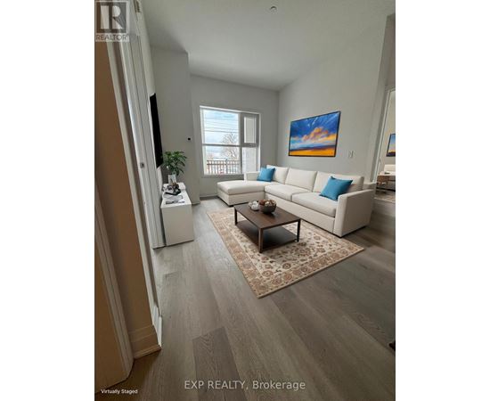 A living room with a white couch and a painting on the wall.