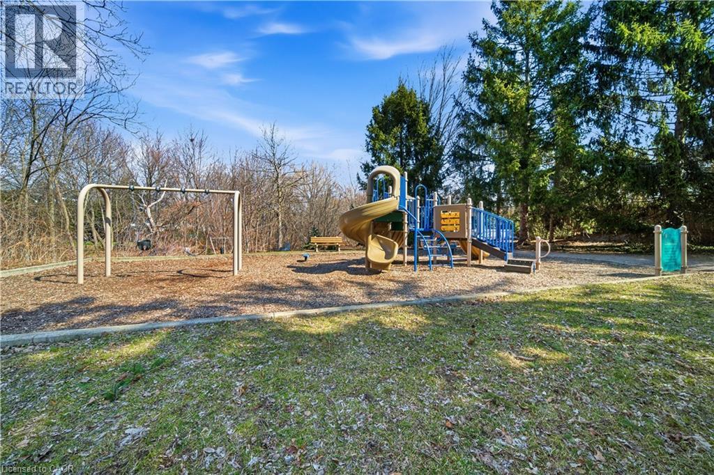 A playground with a slide and swings in a sunny park.