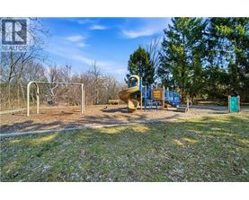 A playground with a slide and swings in a sunny park.