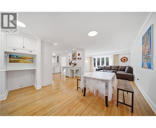 A dining room with a white table and chairs.