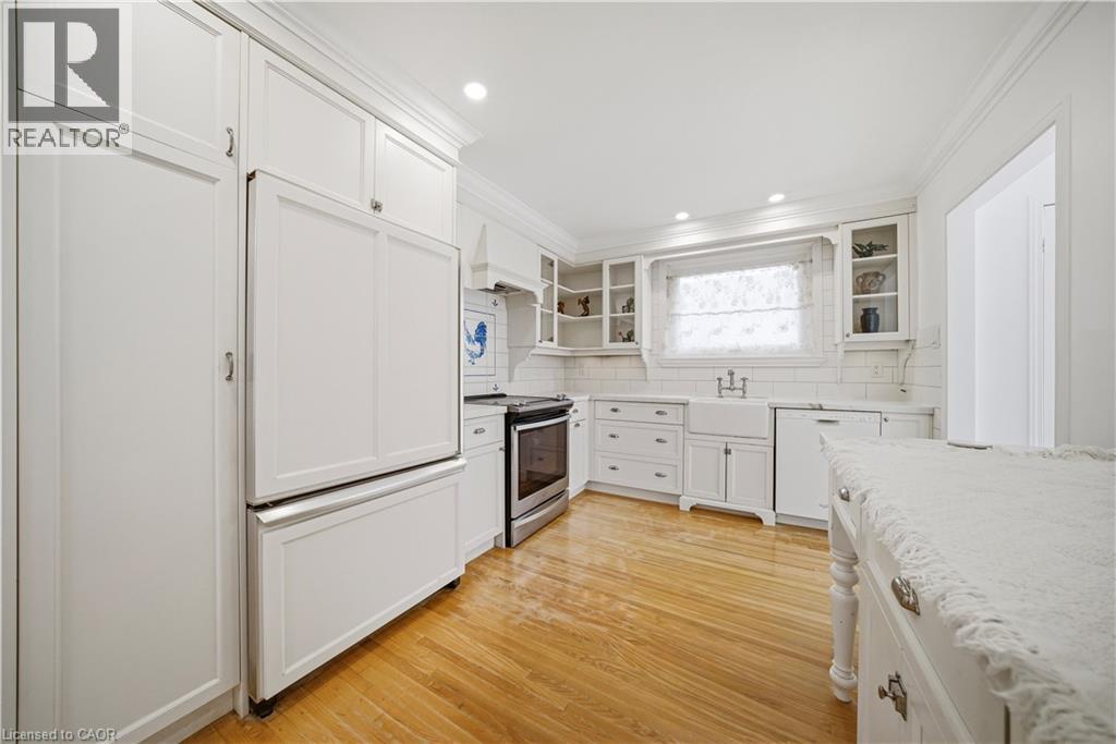 A white kitchen with wooden floors and a refrigerator.