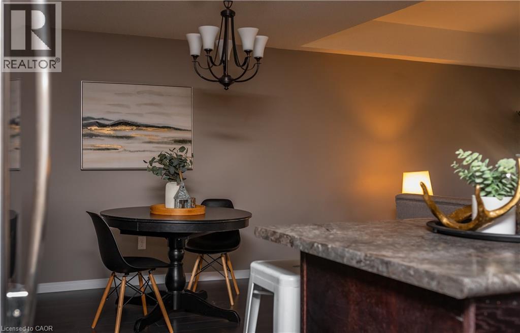 A dining area with a table set for two and a painting on the wall.