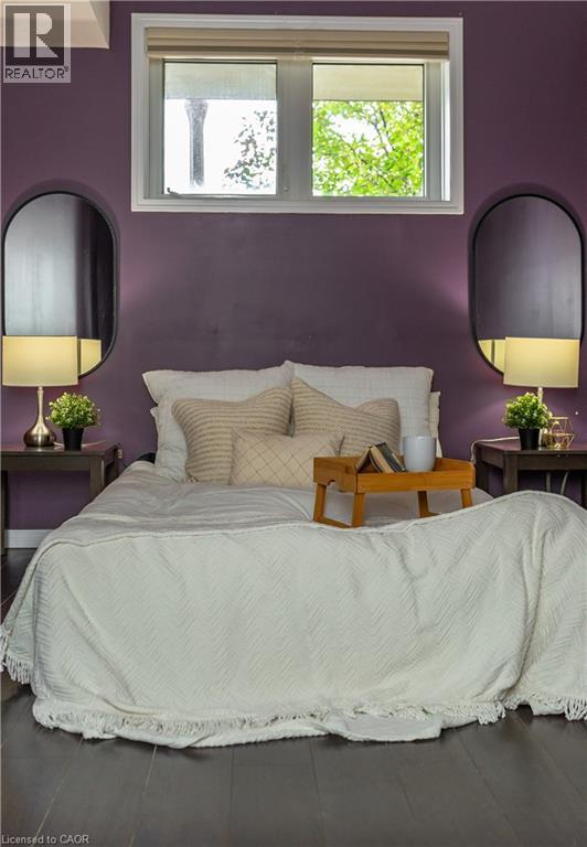 A bedroom with a bed, two lamps, and a window.