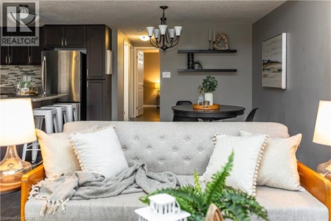 A grey couch with a grey blanket and pillows in a living room.