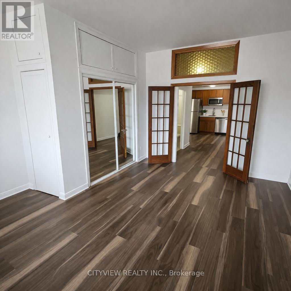 A room with wooden flooring and a mirrored door.