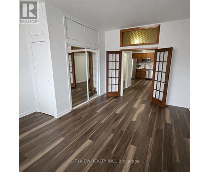 A room with wooden flooring and a mirrored door.