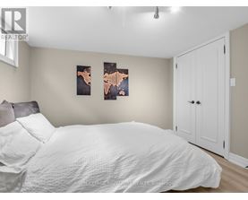 A bedroom with a white bed and two framed pictures on the wall.
