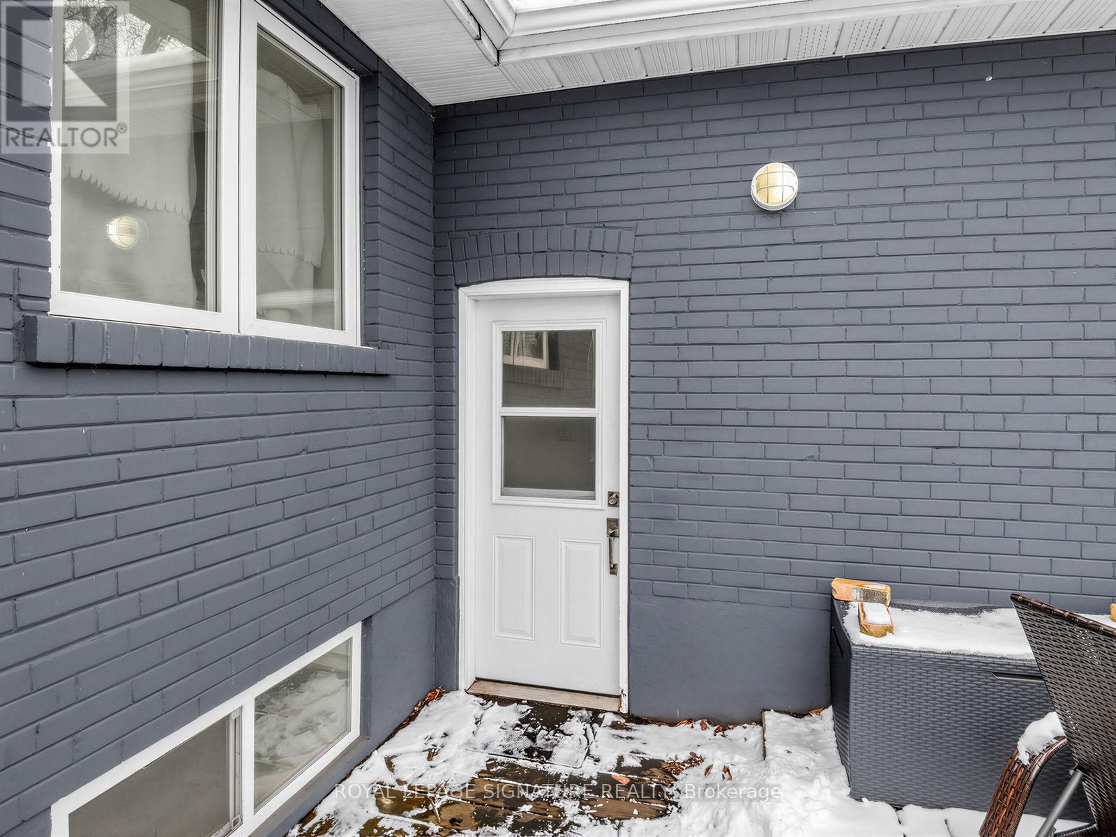 A small white door is on the side of a building.