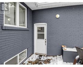 A small white door is on the side of a building.