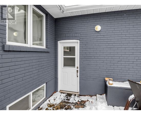 A small white door is on the side of a building.