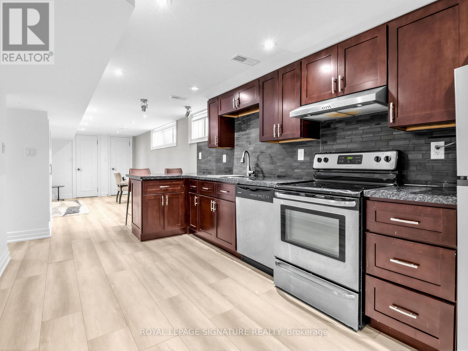 A modern kitchen with wooden cabinets and stainless steel appliances.