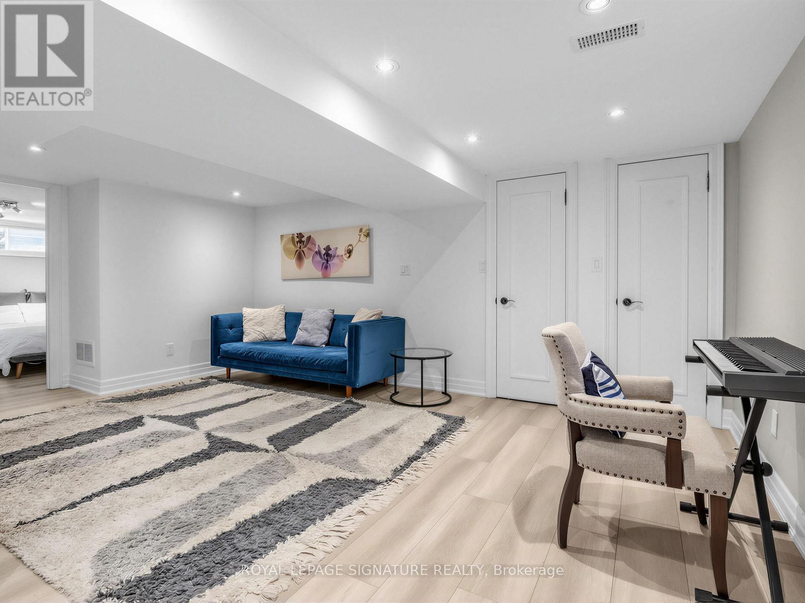 A living room with a blue couch and a rug.