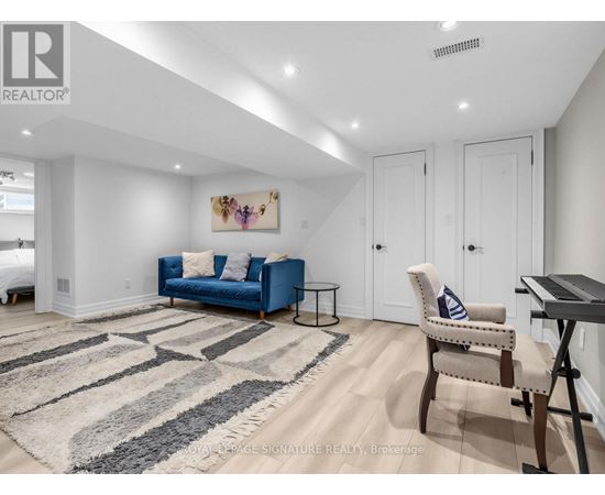 A living room with a blue couch and a rug.