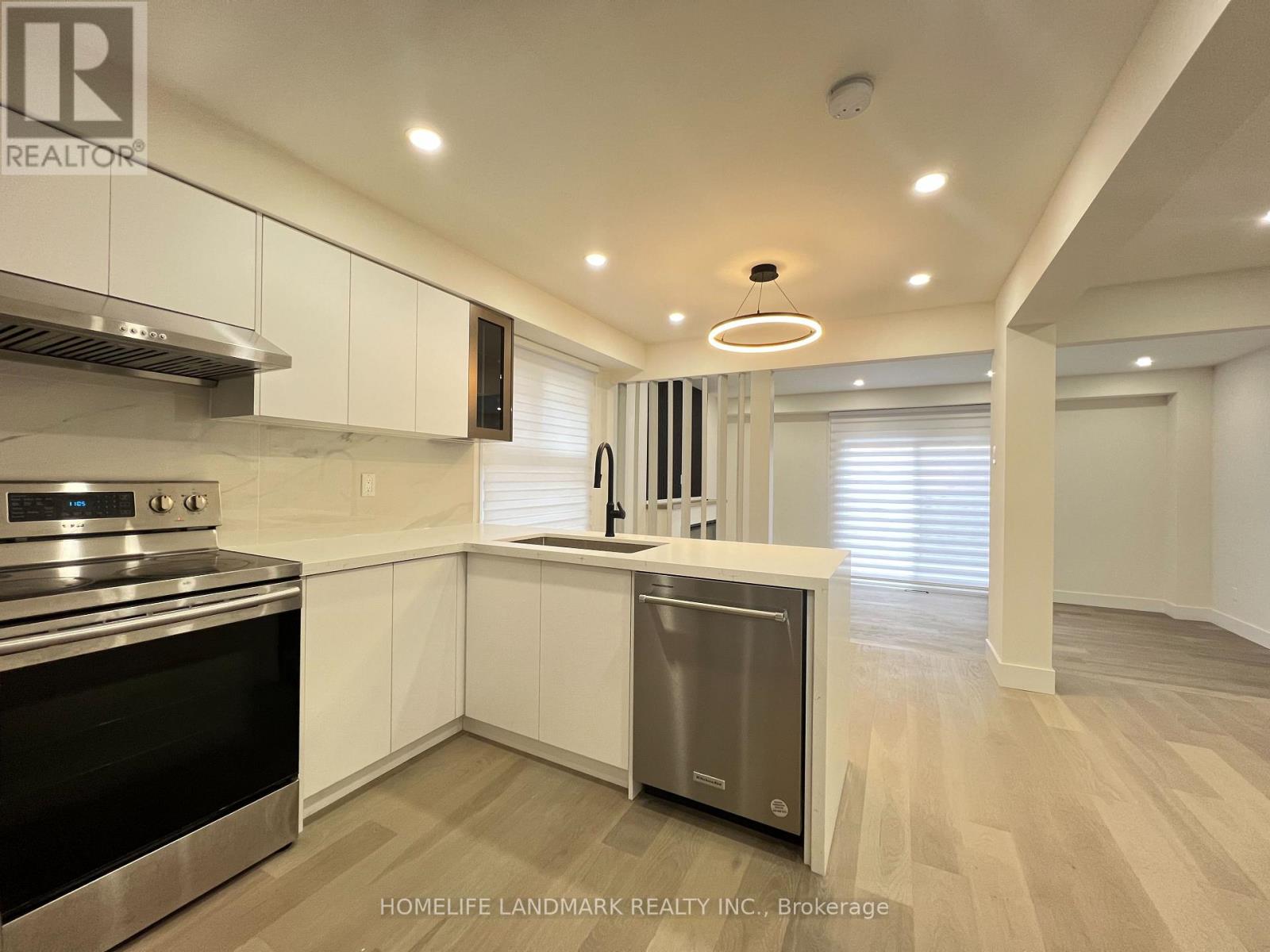 A modern kitchen with white cabinets and stainless steel appliances.