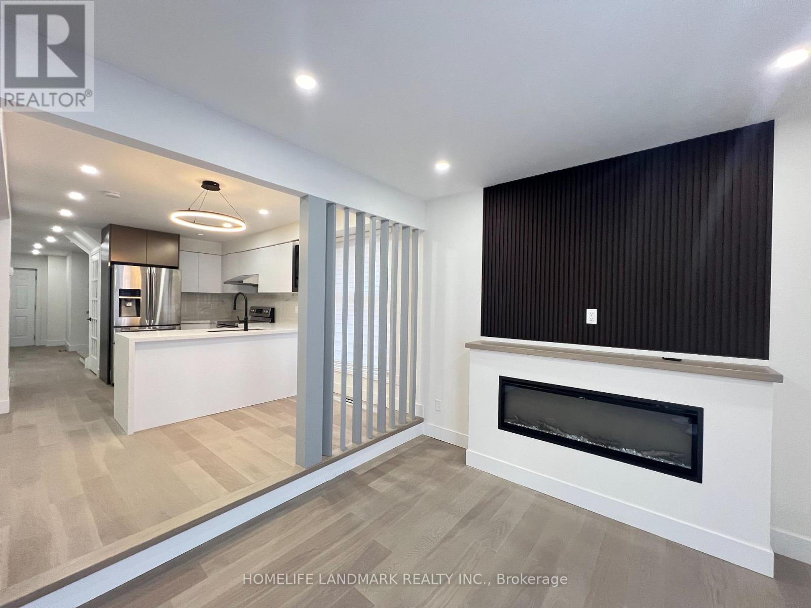 A modern kitchen with a fireplace in the living room.
