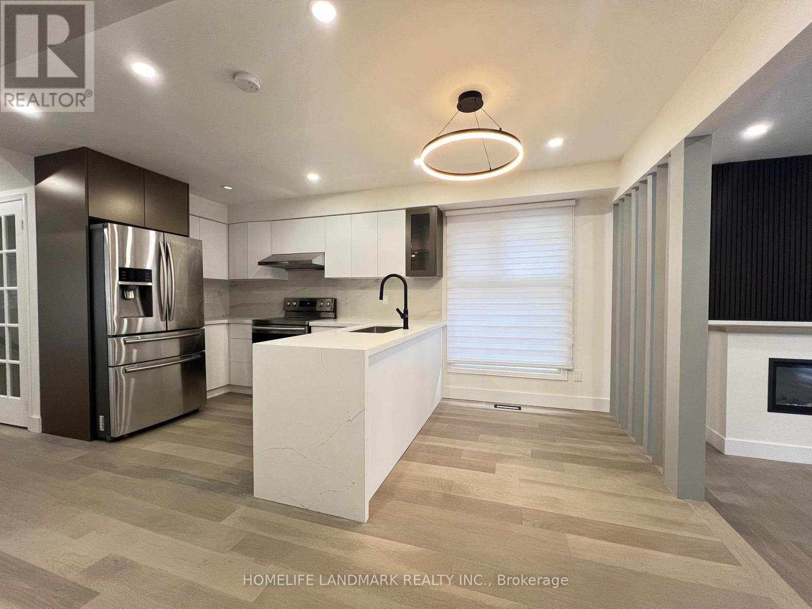 A modern kitchen with a refrigerator, stove, and oven.