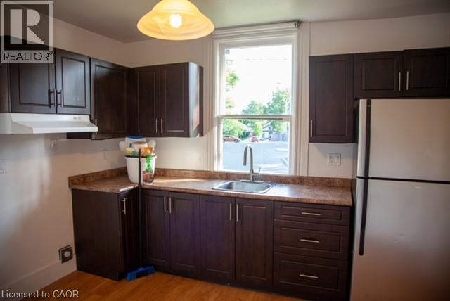 A kitchen with dark brown cabinets and a white refrigerator.