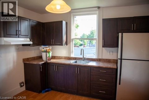 A kitchen with dark brown cabinets and a white refrigerator.