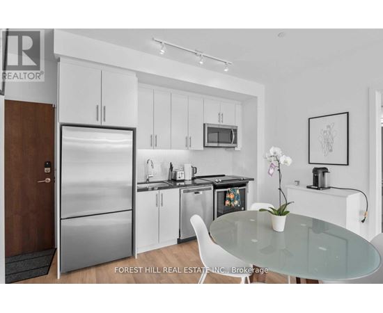 A modern kitchen with a glass table and white chairs.