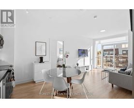A modern dining room with a glass table and white chairs.