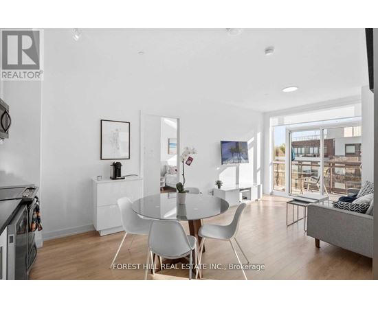 A modern dining room with a glass table and white chairs.