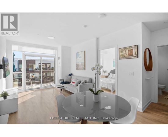 A modern living room with a glass table and white furniture.