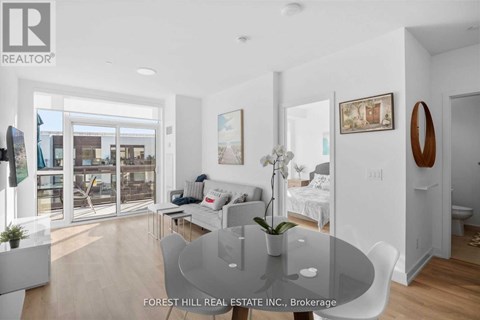 A modern living room with a glass table and white furniture.
