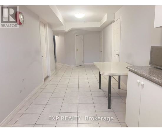 A white tiled hallway with a table and chairs in the foreground.