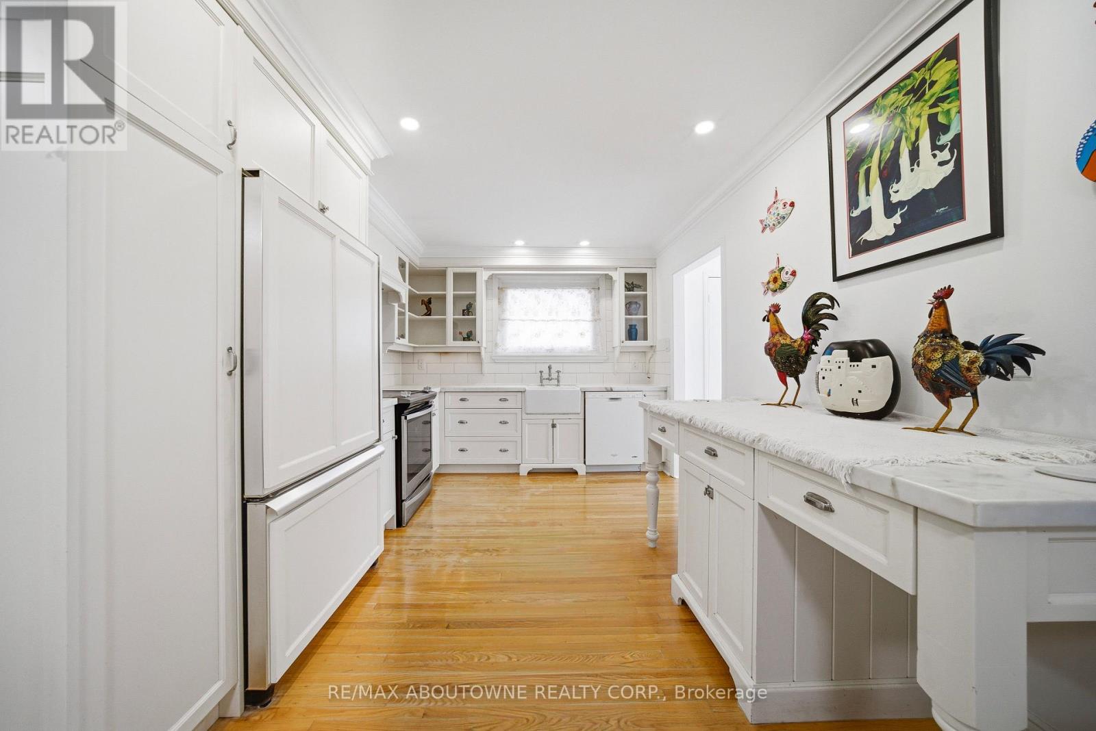 A kitchen with white cabinets and a wooden floor.