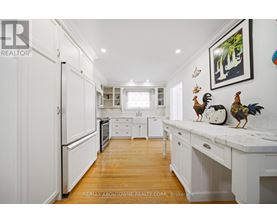 A kitchen with white cabinets and a wooden floor.