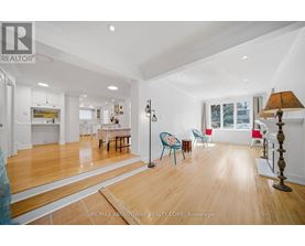 A spacious room with wooden floors and white walls.
