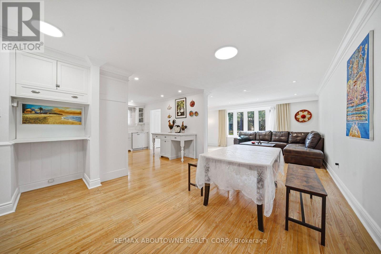 A dining room with a table set for two and a couch.