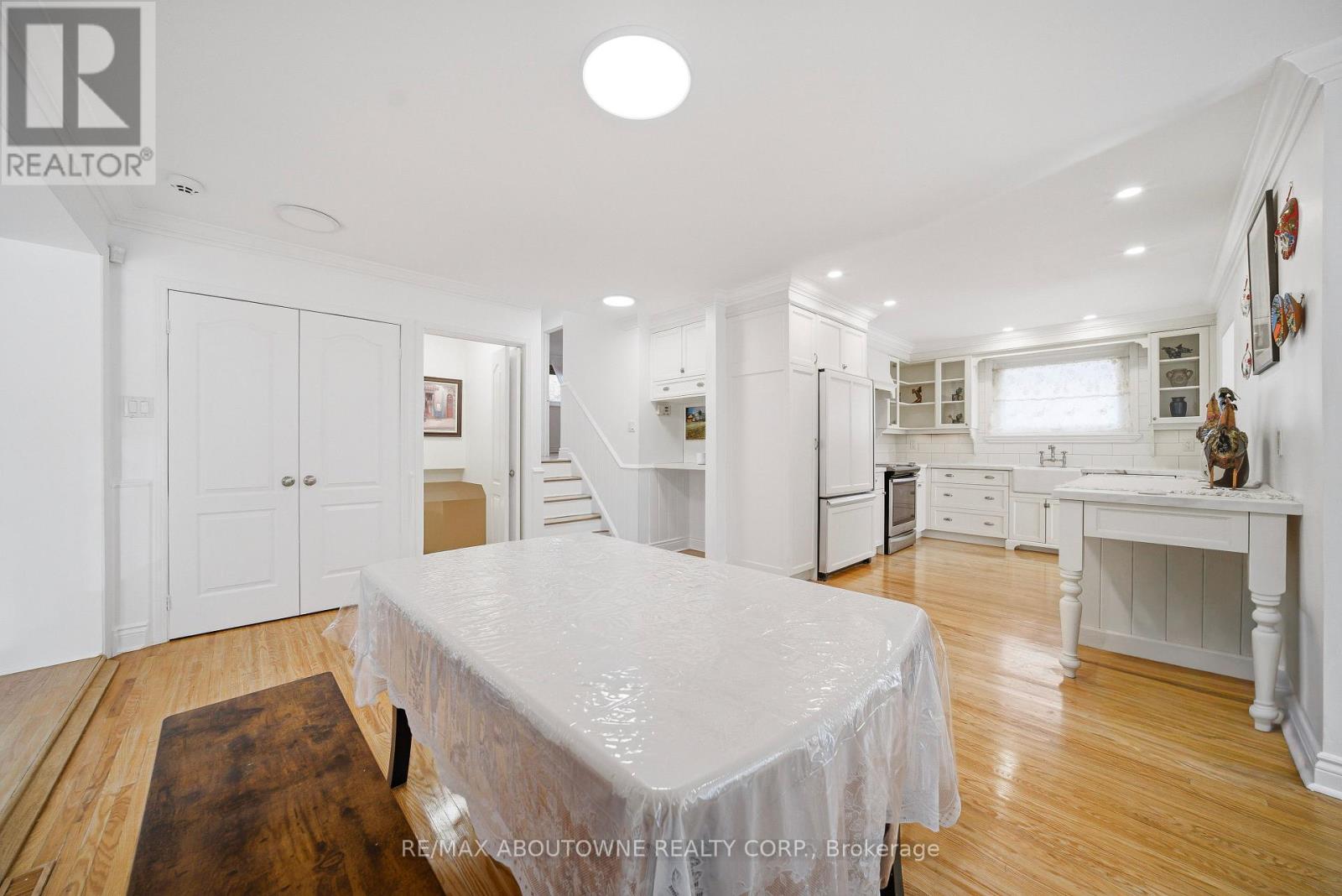 A bedroom with a bed covered in a white sheet and a wooden coffee table in the foreground.