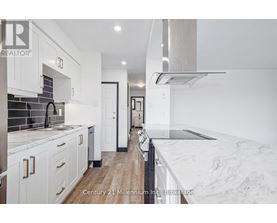 A modern kitchen with white cabinets and a marble countertop.
