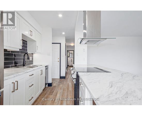A modern kitchen with white cabinets and a marble countertop.
